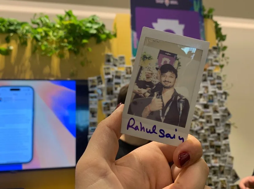 A polaroid signed Rahul Sain held up in front of the event's photo wall